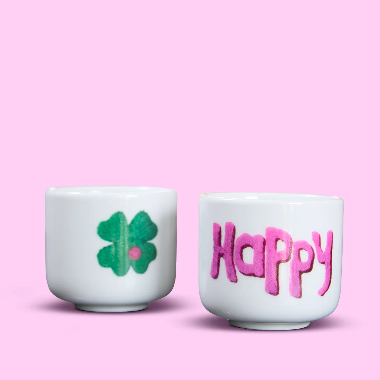 Espressobecher mit Aufschrift in Pink "Happy" und einem grünen Kleeblatt