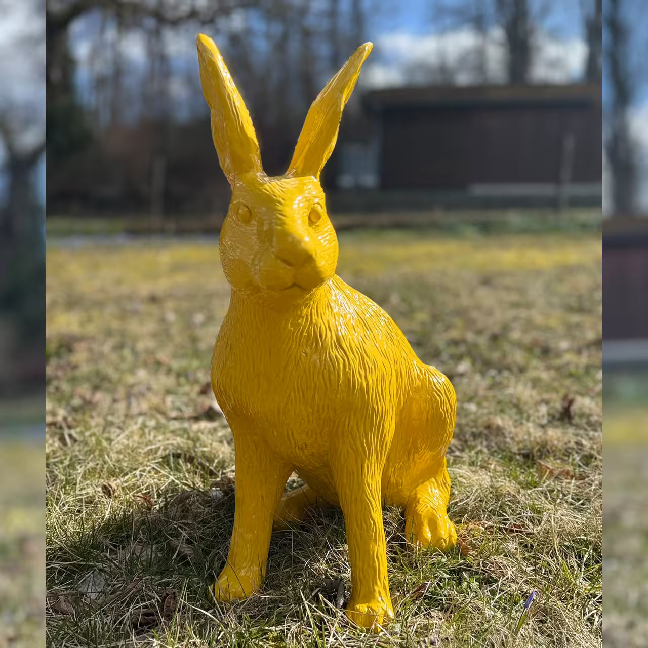 Gelbe Hasenfigur sitzt im Gras