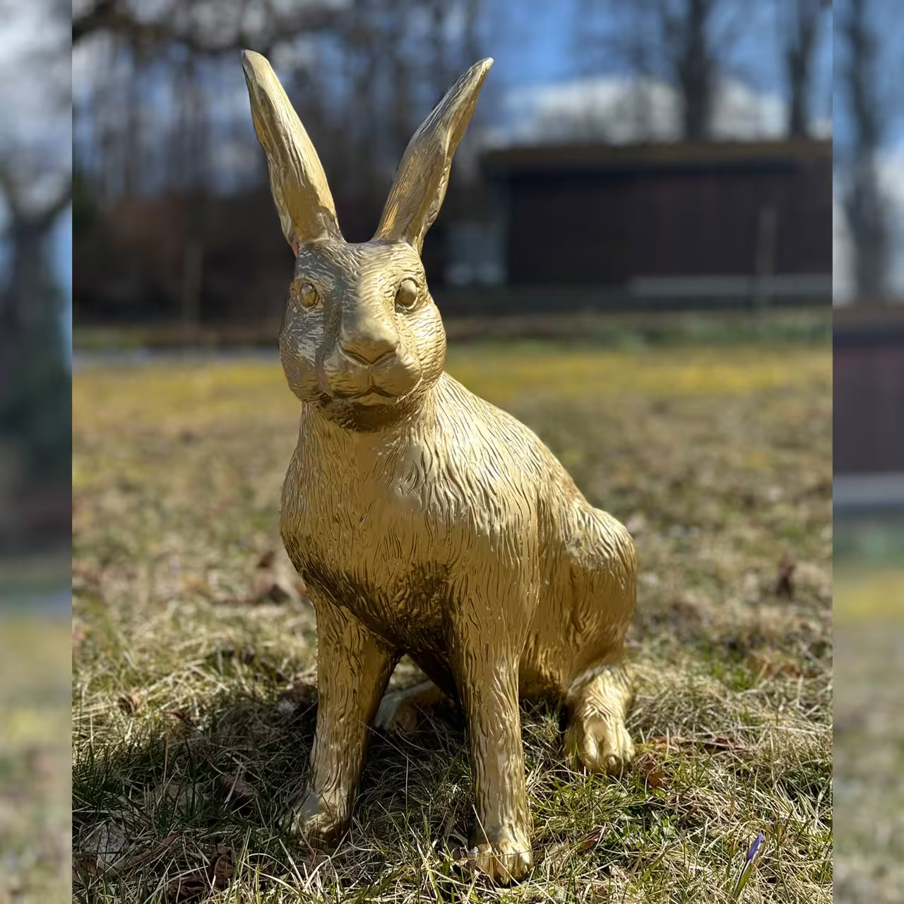 Goldene Hasenfigur sitzt im Gras
