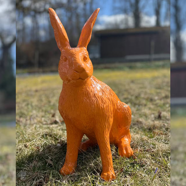 Orange Hasenfigur sitzt im Gras