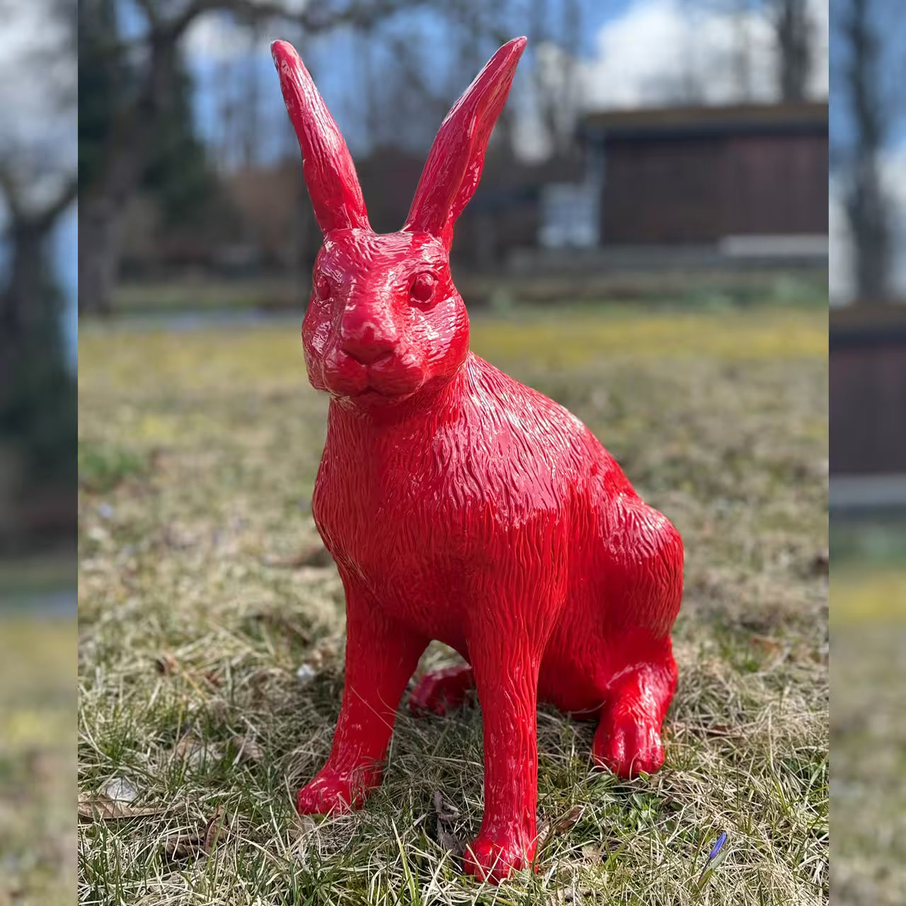 Rote Hasenfigur sitzt im Gras