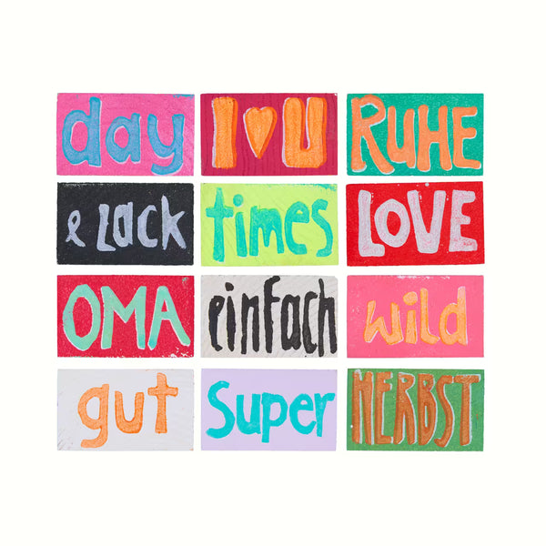Übersicht über 12 Holztäfelchen in bunten Farben mit den Prints day, I [Herz] U, Ruhe, & zack, times, Love, Oma, einfach, wild, gut, Super, Herbst