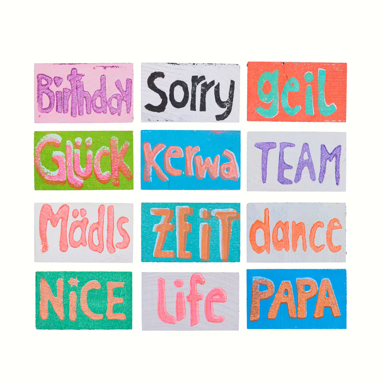 Übersicht über 12 Holztäfelchen in bunten Farben mit den Prints Birthday, Sorry, geil, Glück, Kerwa, Team, Mädls, Zeit, dance, Nice, life, Papa