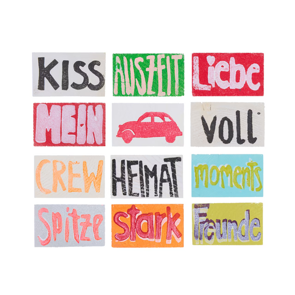 Übersicht über 12 Holztäfelchen in bunten Farben mit den Prints KISS, AUSZEIT, Liebe, MEIN, Auto-Motiv, voll, CREW, HEIMAT, moments, Spitze, stark, Freunde